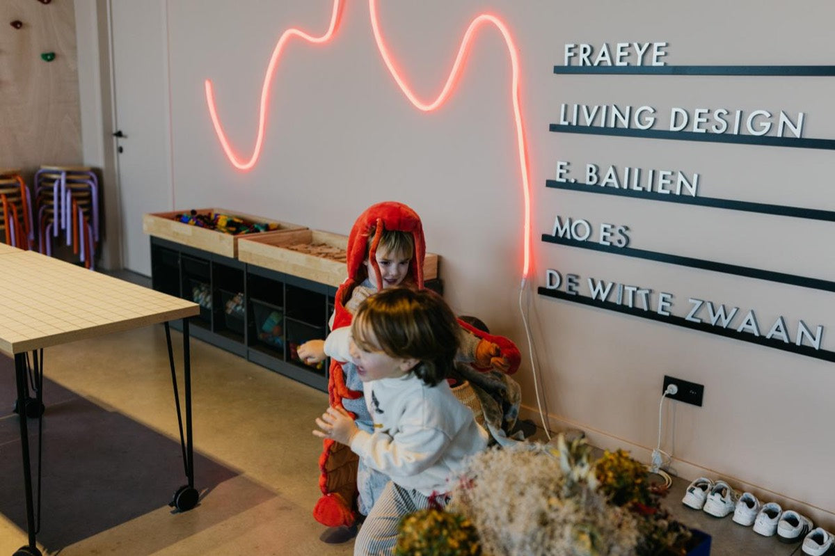 Twee kinderen spelen voor het letterbord